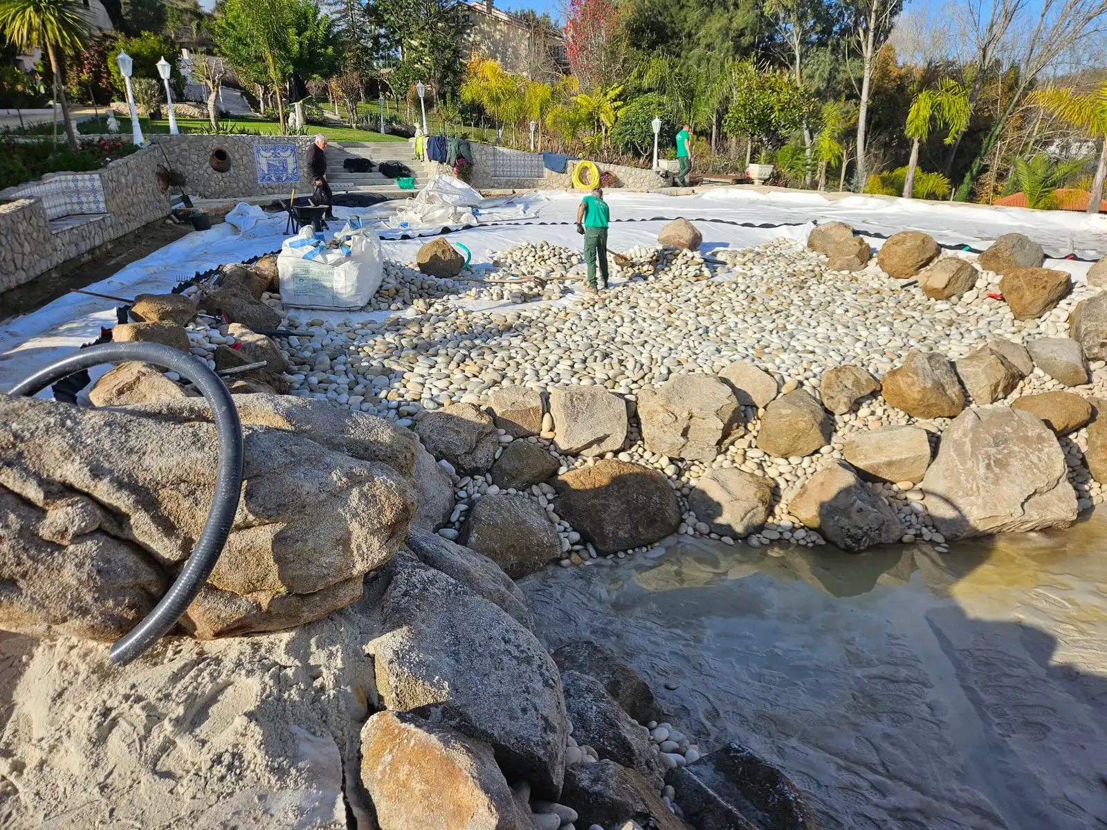 Ouvriers disposant des gros blocs de roche et galets