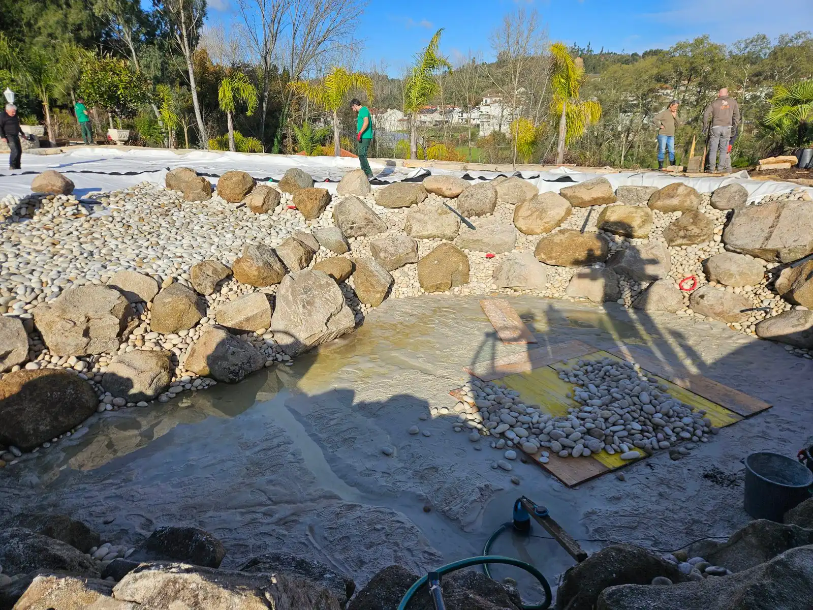 Natural pool construction Workers installing rocks for a bio pool